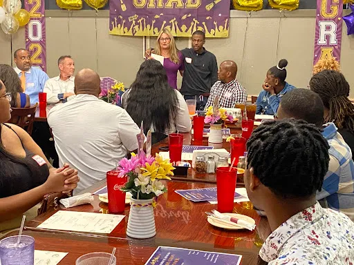 Participants and mentors seated at a decorated graduation dinner table.